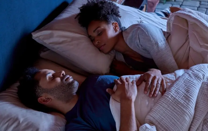 A couple sleeping soundly together in a comfortable bed.
