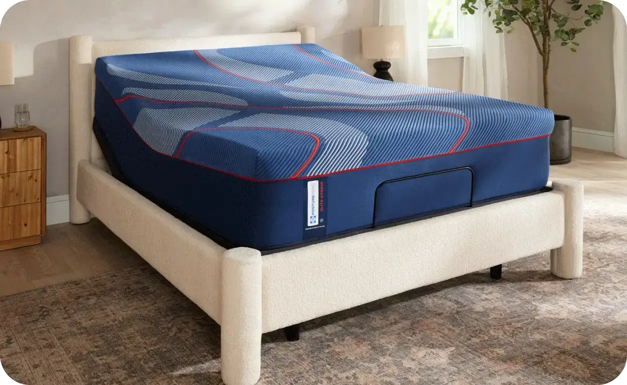 Blue Posturepedic hybrid mattress on an adjustable cream bed frame.