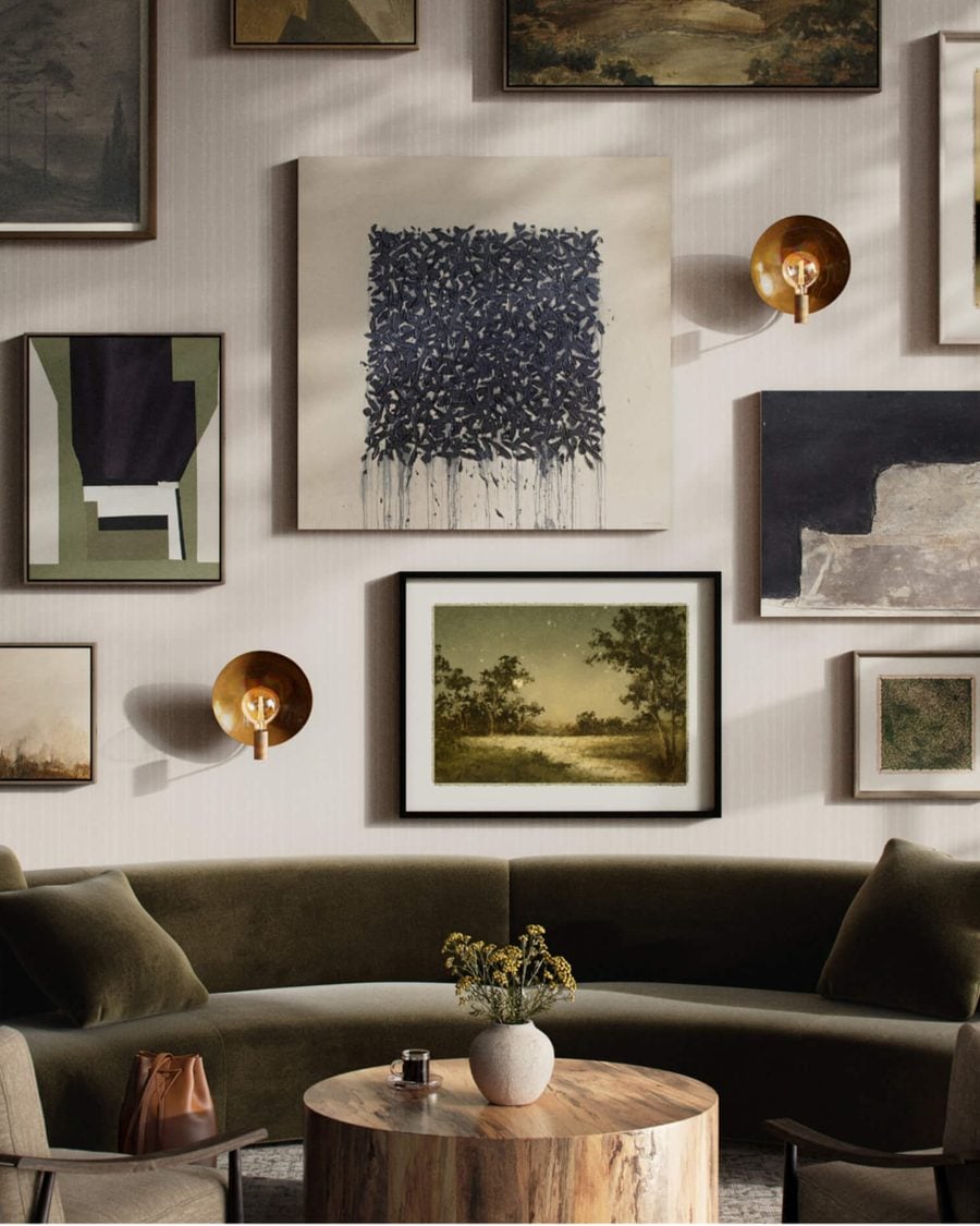 Gallery wall of framed art above a curved sofa